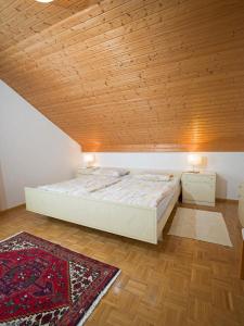 ein Schlafzimmer mit einem Bett und einer Holzdecke in der Unterkunft Ferienwohnung Wilfried Schlor in Merzig