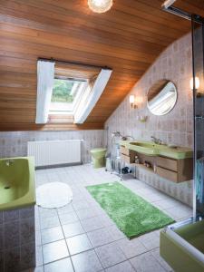 ein Badezimmer mit einer grünen Badewanne und einem Waschbecken in der Unterkunft Ferienwohnung Wilfried Schlor in Merzig