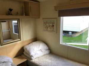 a small room with a bed and a window at Steeple Bay F79 in Steeple