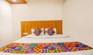 ein Schlafzimmer mit einem Bett mit einer bunten Decke in der Unterkunft FabExpress Sunshine Regency in Bhopal