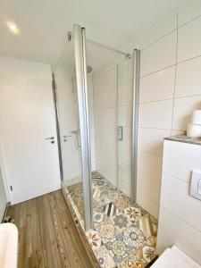 a shower with a glass door in a bathroom at Willinger Perle 69 in Willingen +14 photos
