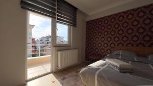 een slaapkamer met een bed en een groot raam bij Edirne House in Edirne