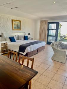 1 dormitorio con 1 cama grande y 1 mesa en Gracelands Beach Lodge, en Ramsgate