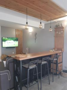 una cucina con un grande bar in legno con sgabelli di bambôô a Les Avirons
