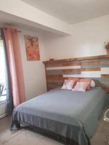 una camera con un grande letto con testiera in legno di bambôô a Les Avirons