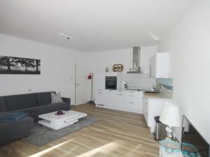 ein Wohnzimmer mit einem Sofa und einer Küche in der Unterkunft Bernstein 17 in Graal-Müritz