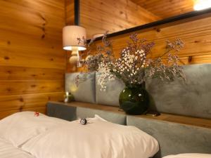 1 dormitorio con un jarrón de flores sobre una mesa en My Happy Garden 1500sq m en Ochsenfurt
