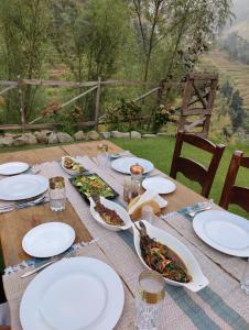 una mesa de madera con platos de comida. en Barei Jungle Lodge en Chamba
