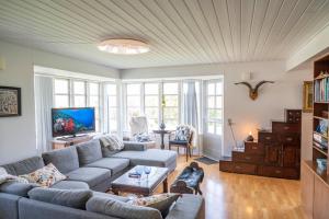 uma sala de estar com um sofá e uma televisão em Skortskær Bondegårdsferie em Havnsø