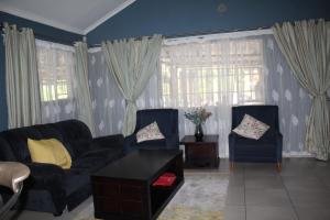 a living room with two chairs and a table at Sable Holiday Home in Hazyview