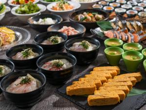 una mesa cubierta con cuencos de diferentes tipos de alimentos en KAMENOI HOTEL Yamato Heguri, en Heguri