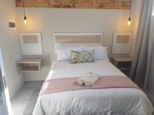 a bedroom with a large bed with two towels on it at Lavender Lane Queenstown in Queenstown