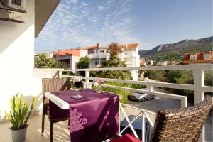 a table with a purple table cloth on a balcony at Beach Guesthouse Mediteran in Podstrana