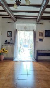 - un salon avec une grande fenêtre et du carrelage dans l'établissement Casa dei Lavatoi Pitigliano, à Pitigliano