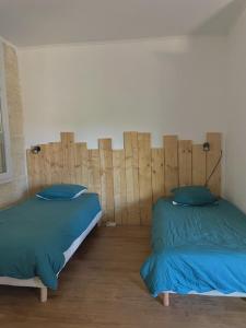 um quarto com 2 camas e almofadas azuis em MaisonFamiliale em Pugnac