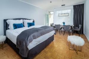 a bedroom with a large bed and a table and chairs at Blue Sky Apart Center Baden-Baden in Baden-Baden