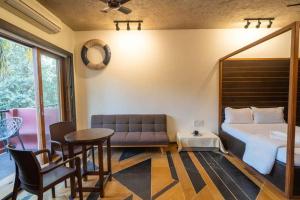 una camera da letto con un letto, un tavolo e un divano di Walk to Calangute beach from this beautiful studio a Calangute