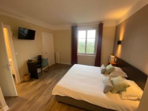 Un dormitorio con una cama grande y una ventana en Hotel De La Poste, en Mortain