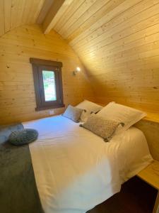 een slaapkamer met een wit bed in een houten hut bij Domaine du Heidenkopf in Niederbronn-les-Bains
