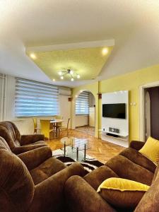un soggiorno con 2 divani e un tavolo di Lux Apartman Cvetkovic a Kraljevo