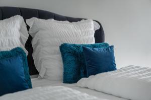 Una cama con almohadas azules y blancas. en Blue Sky Apartment City Center Baden-Baden, en Baden-Baden