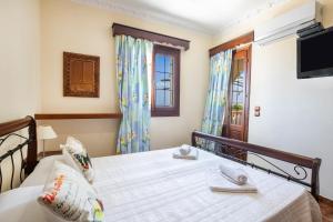 a bedroom with a bed and a tv on the wall at Oceanviewvilla in Karpathos