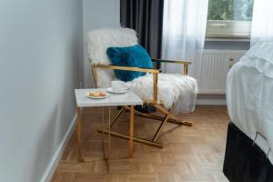 una silla con una mesa junto a la cama en Blue Sky Apartment City Center Baden-Baden, en Baden-Baden