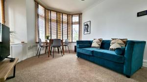 sala de estar con sofá azul y mesa en Thompson Apartments by Switchback Stays, en Cardiff
