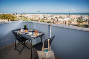 a table and chairs on a balcony with a view of the ocean at Residence Hotel Piccadilly in Rimini