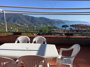 d'une table et de chaises blanches sur un balcon avec vue. dans l'établissement Portofino Est Residence, à Rapallo