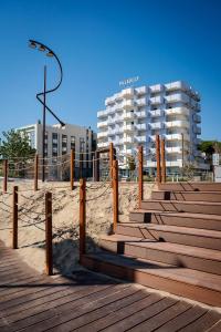 una playa de arena con escalones de madera y un edificio en Residence Hotel Piccadilly, en Rímini