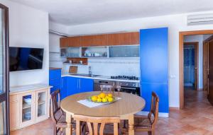 a kitchen with blue cabinets and a table with fruit on it at Appartamento incantevole con vista mare in Buoncammino +46 photos