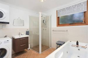 ein Badezimmer mit Dusche, Badewanne und Waschbecken in der Unterkunft Leura Maples 1BR Cosy Cottage Minutes to village in Leura + 3 Fotos