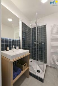 une salle de bain avec lavabo et douche dans l'établissement Haus am Dorfbrunnen Ferienwohnung Meer, à Wangerooge