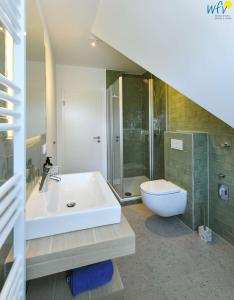 ein Badezimmer mit Waschbecken, Dusche und Toilette in der Unterkunft Haus am Dorfbrunnen Ferienwohnung Düne in Wangerooge + 27 Fotos