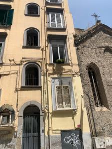 een geel gebouw met ramen en een gebouw met graffiti bij Sellaria4 Guest House in Napels +13 foto's