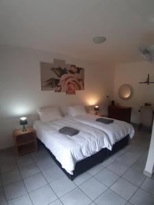 um quarto com uma grande cama branca num quarto em Wayside Lodge em Waterval Boven