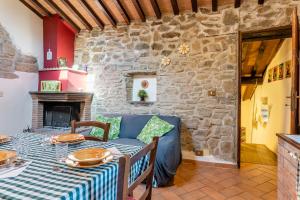 a dining room with a table and a stone wall at Il Colletto Romantic Stonehouse in Pescia