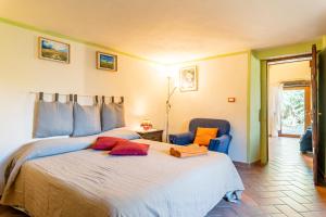 a bedroom with a large bed and two chairs at Il Colletto Romantic Stonehouse in Pescia