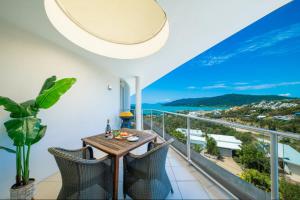 a dining room with a view of the ocean at Pacific Blue Whitsunday - Studio in Airlie Beach