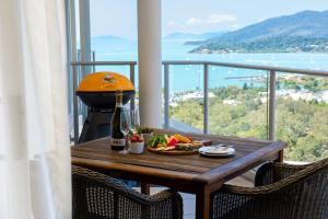 a table with a plate of fruit and a bottle of wine at Pacific Blue Whitsunday - Studio in Airlie Beach
