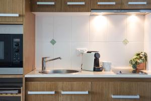 a kitchen with a sink and a microwave at Pacific Blue Whitsunday - Studio in Airlie Beach