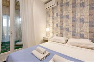 1 dormitorio con 1 cama grande y toallas. en Beach Hut * Green oasis with private patio 10 min to Palais & beaches * Pet Friendly en Cannes