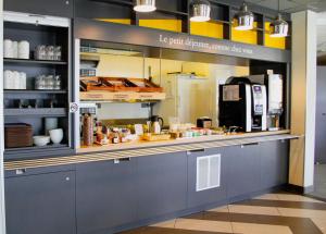 a kitchen with a counter with food items in it at B&B HOTEL Montélimar Sud in Montélimar