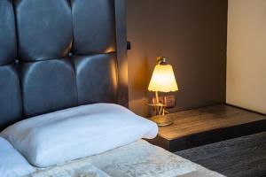 a bedroom with a bed with a leather headboard and a lamp at Oceanviewvilla in Karpathos