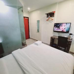 a bedroom with a bed and a flat screen tv at Sunrise Golden Hotel in Kajang +21 photos