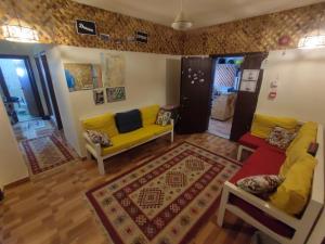 uma sala de estar com um sofá amarelo e um tapete em Hakaia Community em Aqaba