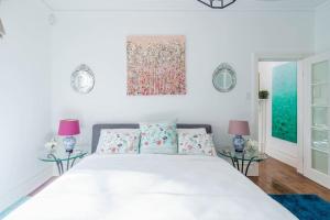 a bedroom with a large white bed with two tables at Bryn-y-Mor Cottage Romantic Fireplace Couples in Leura