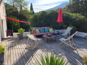 a patio with a couch and two chairs and an umbrella at Villa Caprier in Le Pradet