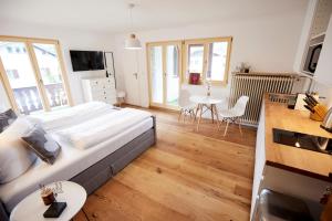 ein Schlafzimmer mit einem großen Bett und einem Tisch mit Stühlen in der Unterkunft Apartmenthaus am Tegernsee - Studios mit Küchenzeile und mit Bus erreichbar in Bad Wiessee